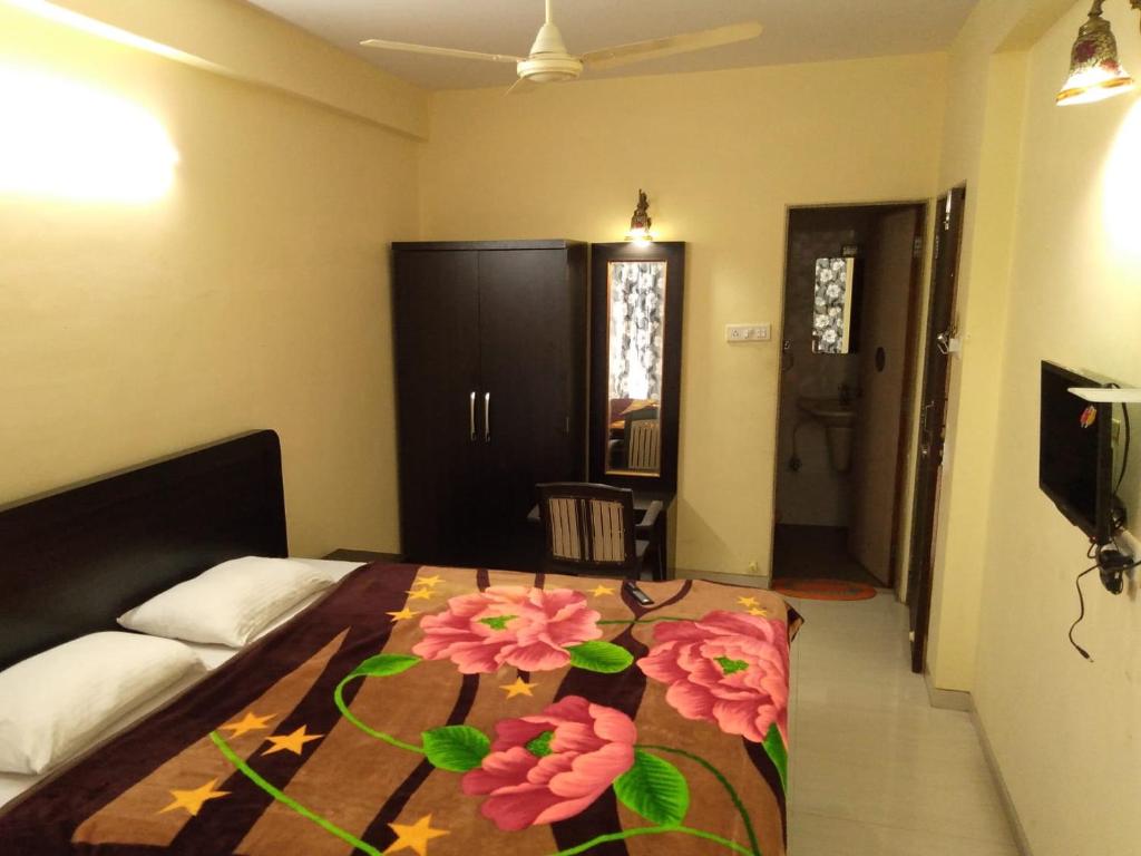 Un dormitorio con una cama con flores. en SALAS EXECUTIVE, en Mahabaleshwar