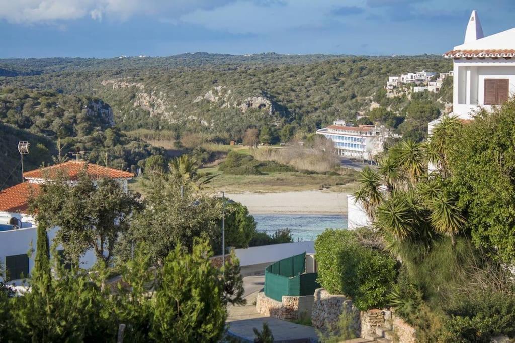 a view of a beach with buildings and trees at Modernes Apartment mit traumhaftem Blick Vistamar3 in Cala'n Porter
