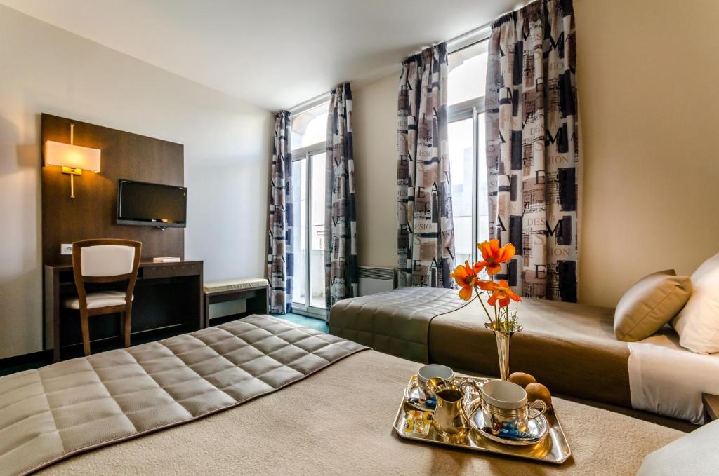 Postel nebo postele na pokoji v ubytování Hôtel Croix des Bretons - Lourdes Pyrénées