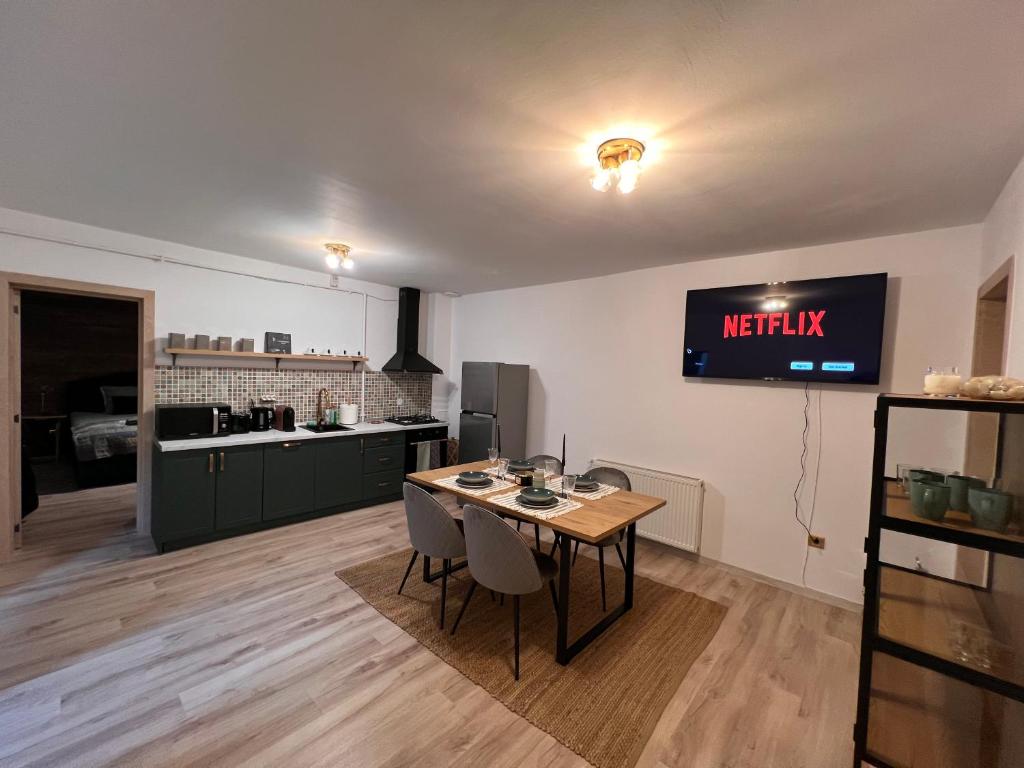 een keuken met een tafel en een tv aan de muur bij Green Home in Miercurea-Ciuc