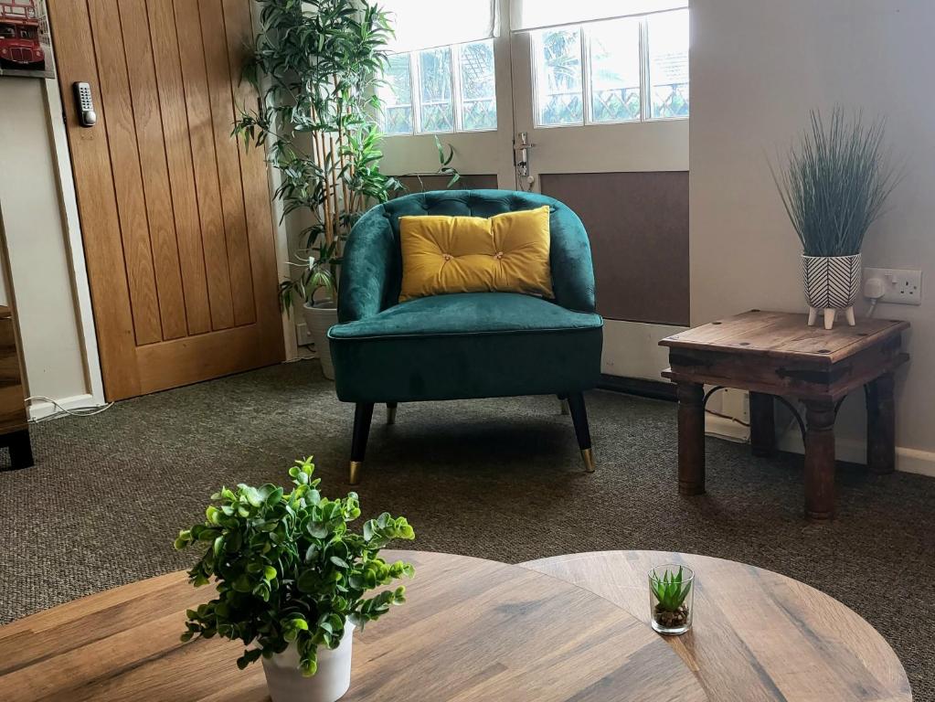 ワージングにあるSouthcourtの緑の椅子(テーブル上に黄色の枕付)