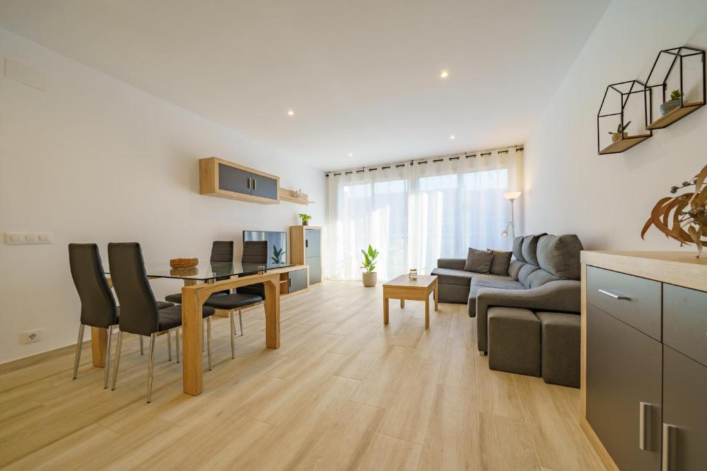 eine Küche und ein Wohnzimmer mit einem Tisch und Stühlen in der Unterkunft HomeHolidaysRentals Music - Costa Barcelona in Pineda de Mar