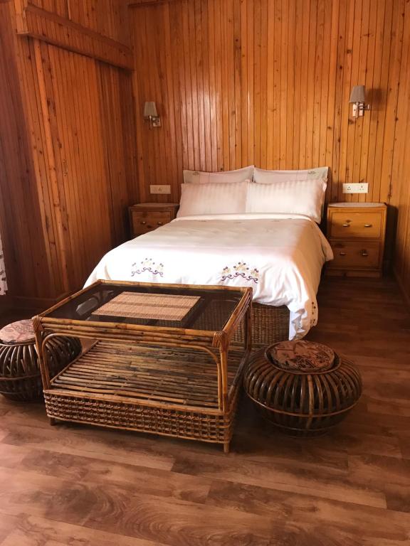 a bedroom with a bed with a wooden wall at SEWANS PLACE Homestay in Mirik