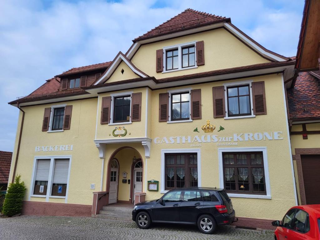 ein schwarzes Auto, das vor einem Gebäude parkt in der Unterkunft Gasthaus zur Krone in Weisenbach