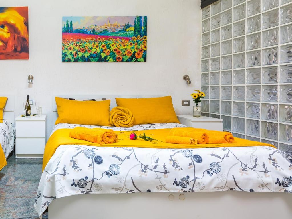 拿坡里的住宿－Museo Filangieri Apartment-Suite，一间卧室配有一张黄色床单和墙上的绘画。