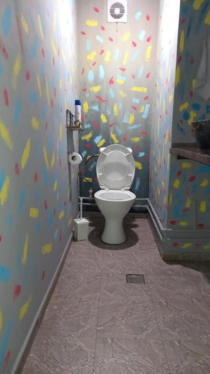 een badkamer met een toilet in een kamer met kleurrijk behang bij YOUR ROOM in Tbilisi City