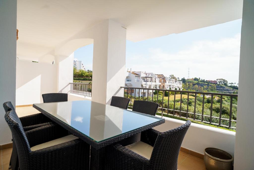 jadalnia ze stołem i krzesłami oraz balkonem w obiekcie Los Robles de Los Arqueros golf 3 bedrooms apartment. w mieście Benahavís
