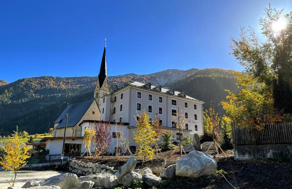 a large white building with a church with a steeple at B&B Villa Stelvio in Sta Maria Val Müstair