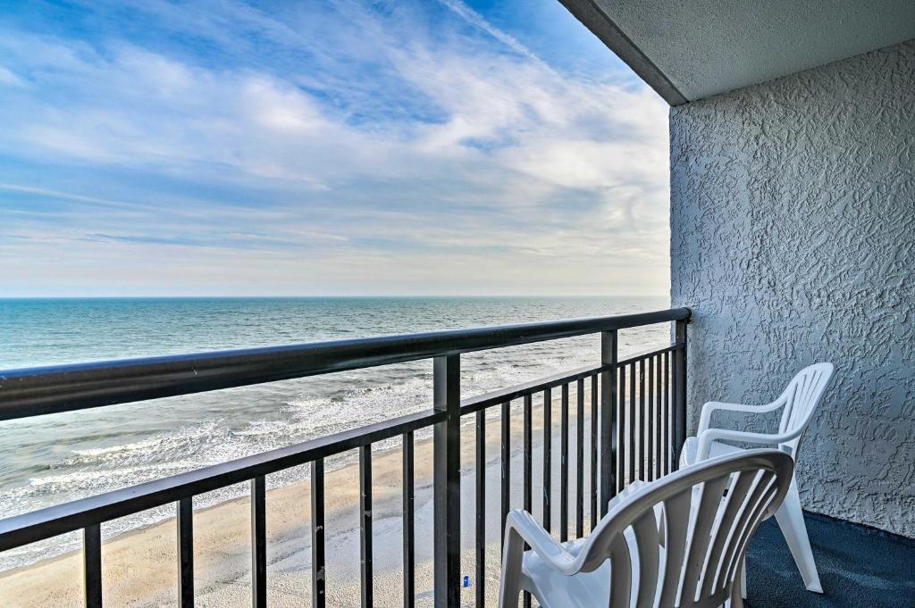 - deux chaises blanches assises sur un balcon donnant sur la plage dans l'établissement Oceanfront Balcony Resort Condo in Myrtle Beach, à Myrtle Beach