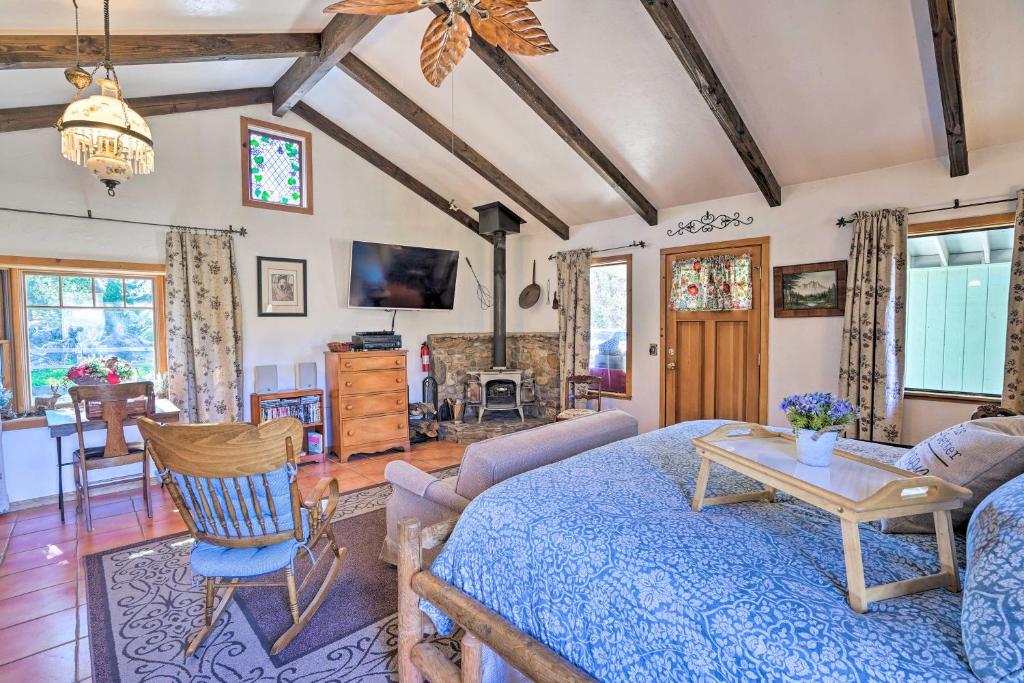 a living room with a blue bed and a table at Cozy Story Book Barn Cottage with Scenic View in Julian