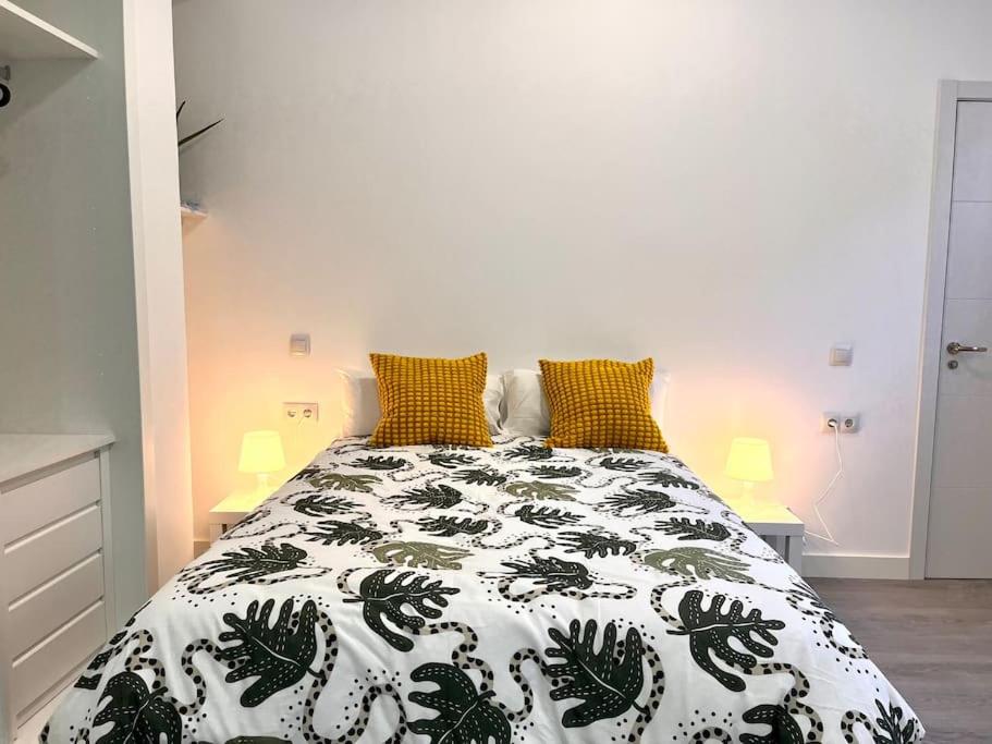 a bedroom with a bed with a black and white comforter at Cool Space in Madrid