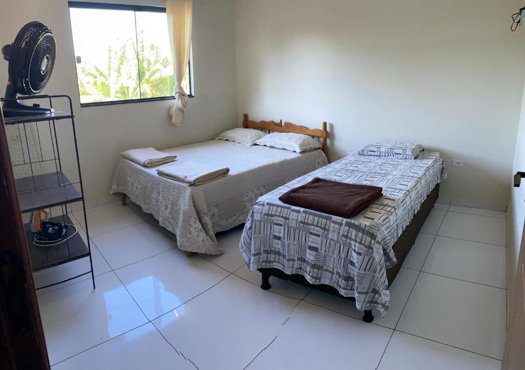a bedroom with two beds and a window at Chacara Pe. Cicero in Triunfo