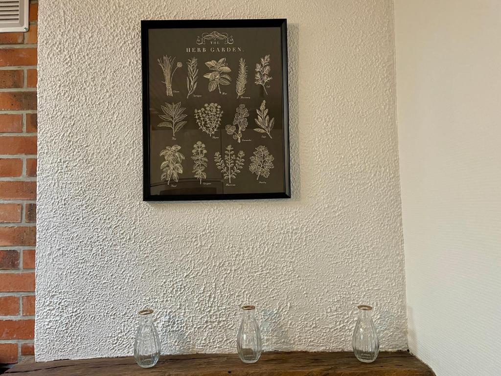 a picture on a wall with two glass vases on a table at La Renaissance in Bayeux
