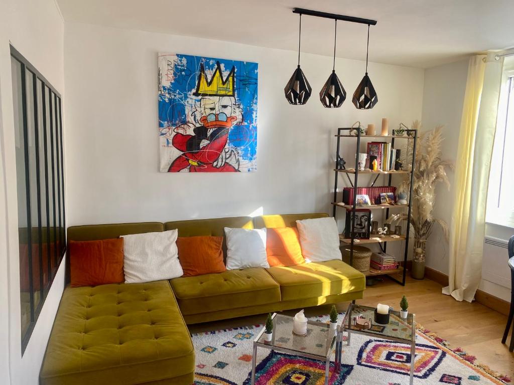 a living room with a couch and a crown on the wall at Les mouettes de Trouville in Trouville-sur-Mer