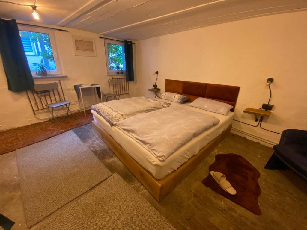 een slaapkamer met een bed en een woonkamer met stoelen bij Art Boutique Budget Apartment im Hinterhof Menden Altstadt in Menden