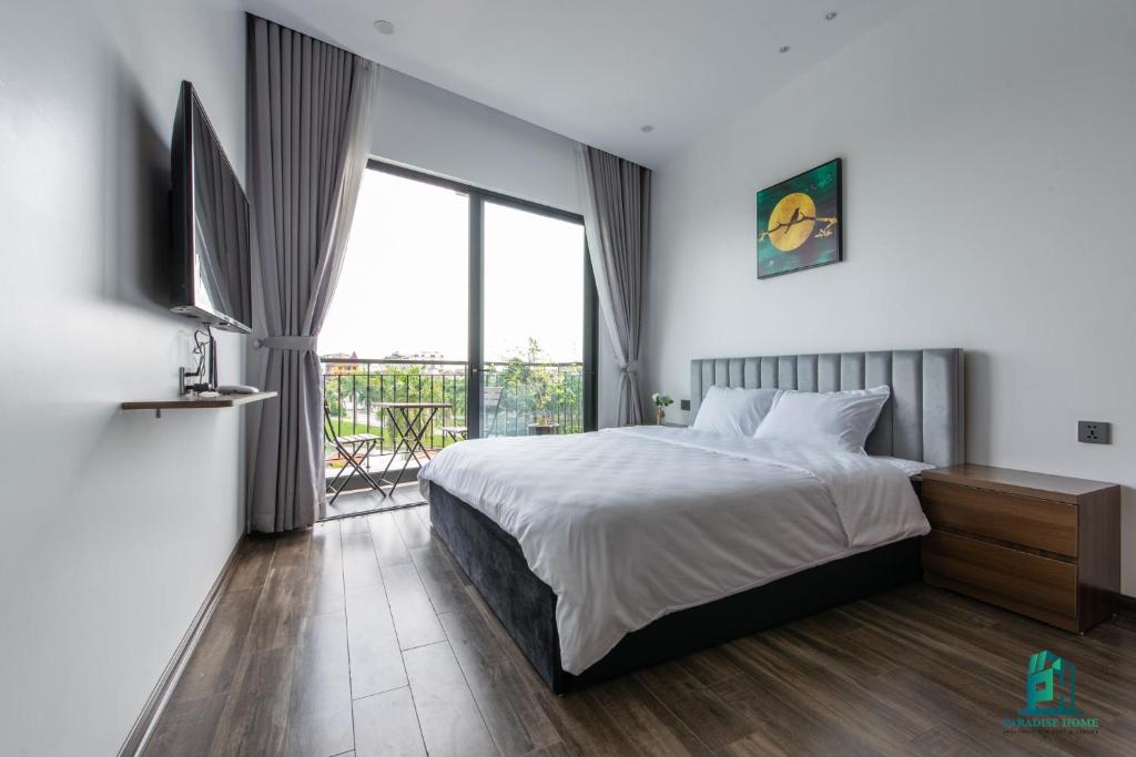 a bedroom with a bed and a large window at Luxe Paradise Residence 5 Tu Hoa in Hanoi