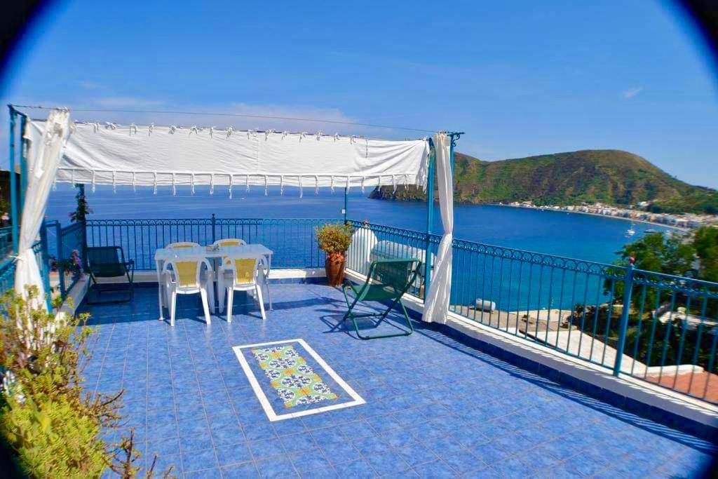 a balcony with tables and chairs and a view of the water at Holiday Home Case Blu in Lipari