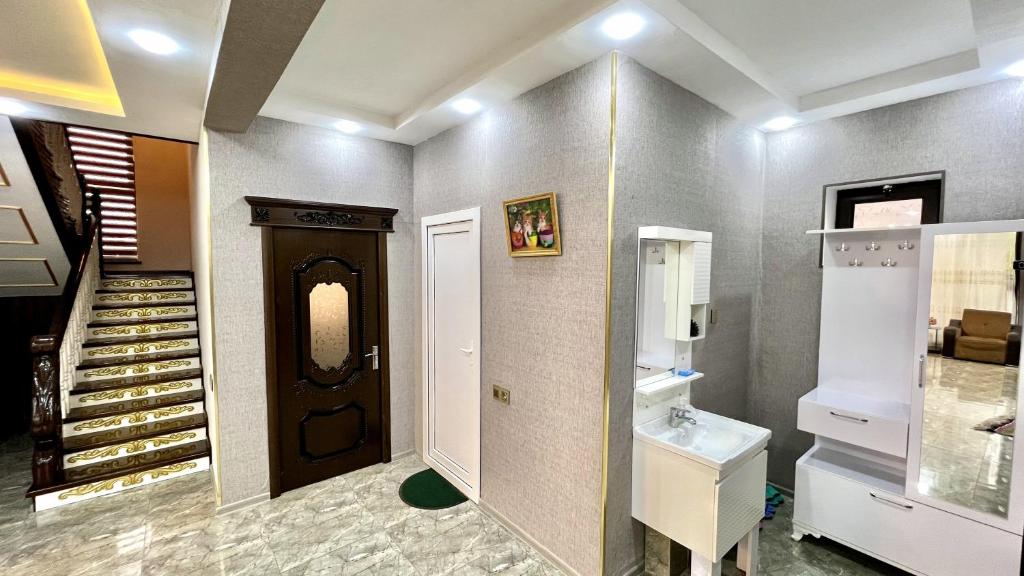 uma casa de banho com uma porta, um lavatório e uma escada em Gabala luks house em Gabala