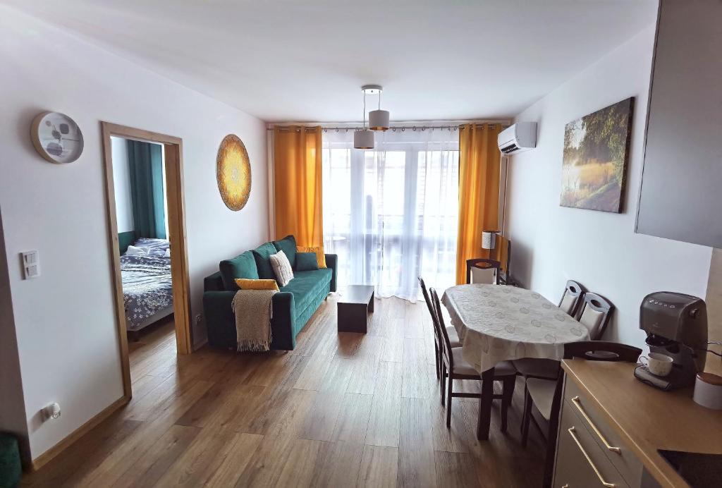 a living room with a green couch and a table at Apartament Olecko Centrum in Olecko