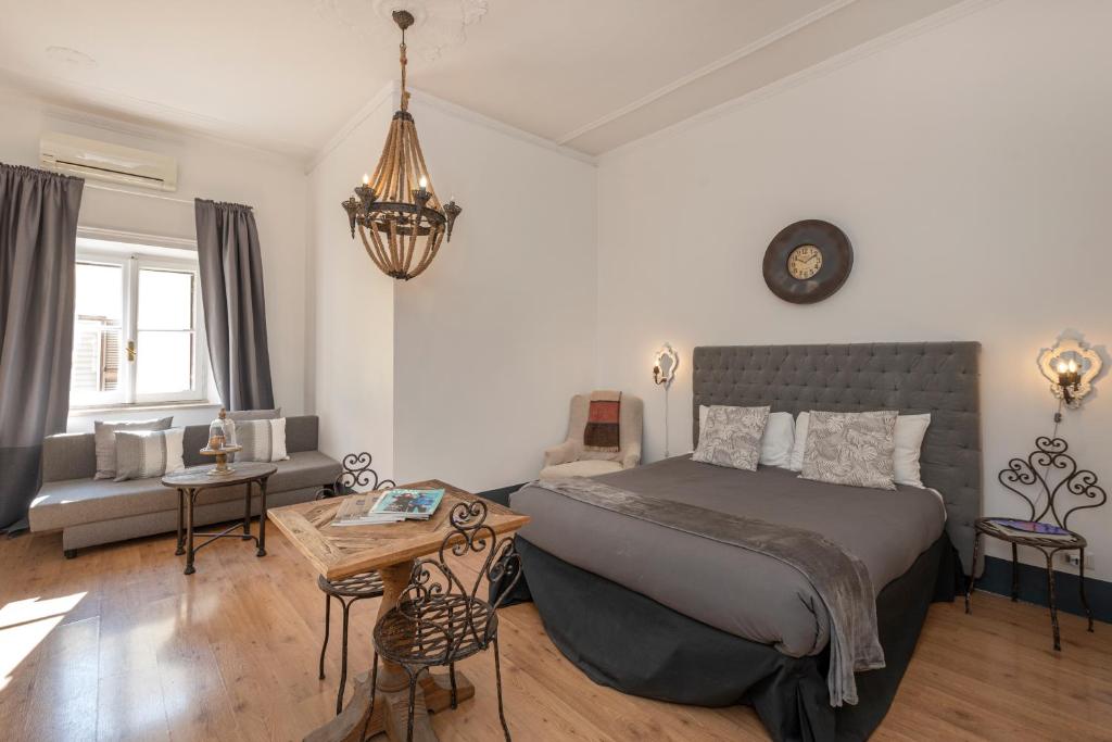 a bedroom with a bed and a couch and a table at Angelina Dimora Contemporanea in Rome