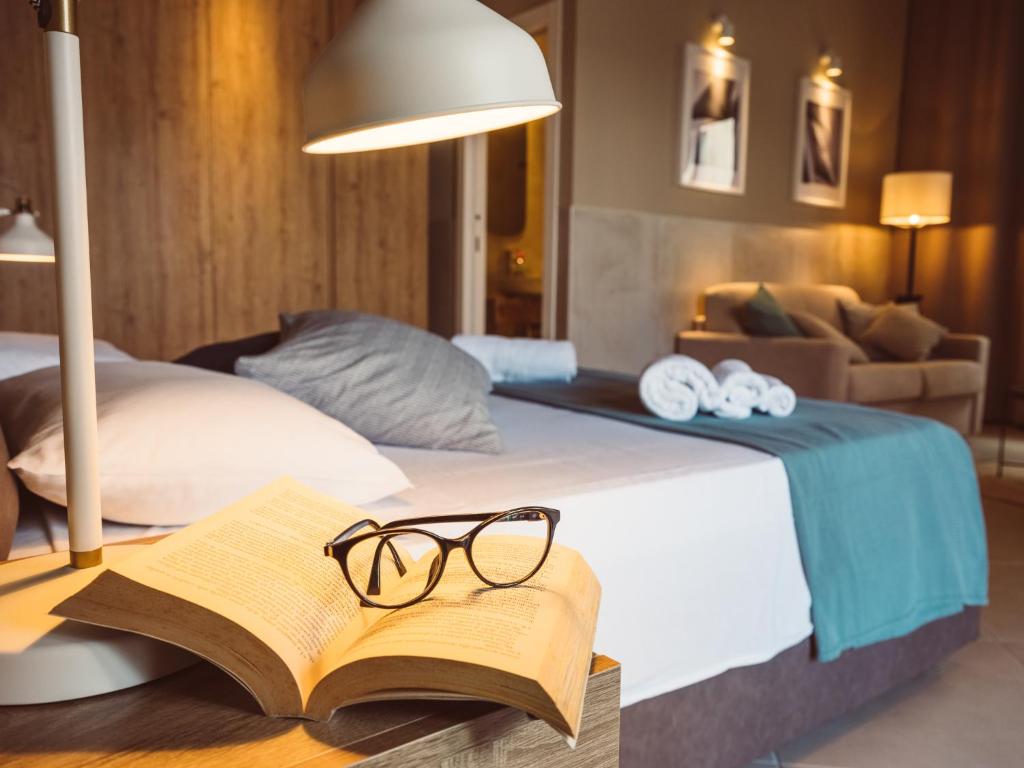 una cama con un libro y gafas sobre una mesa en B&B Casa di Gio', en Tiggiano