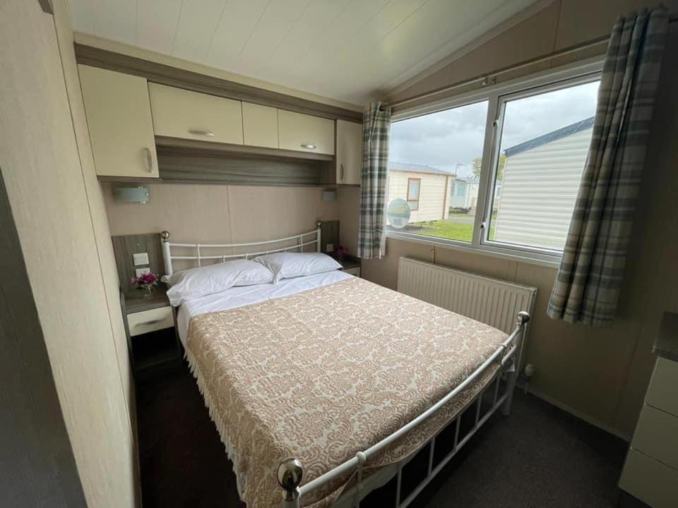 ein Schlafzimmer mit einem Bett und einem großen Fenster in der Unterkunft Marine Holiday Park in Rhyl