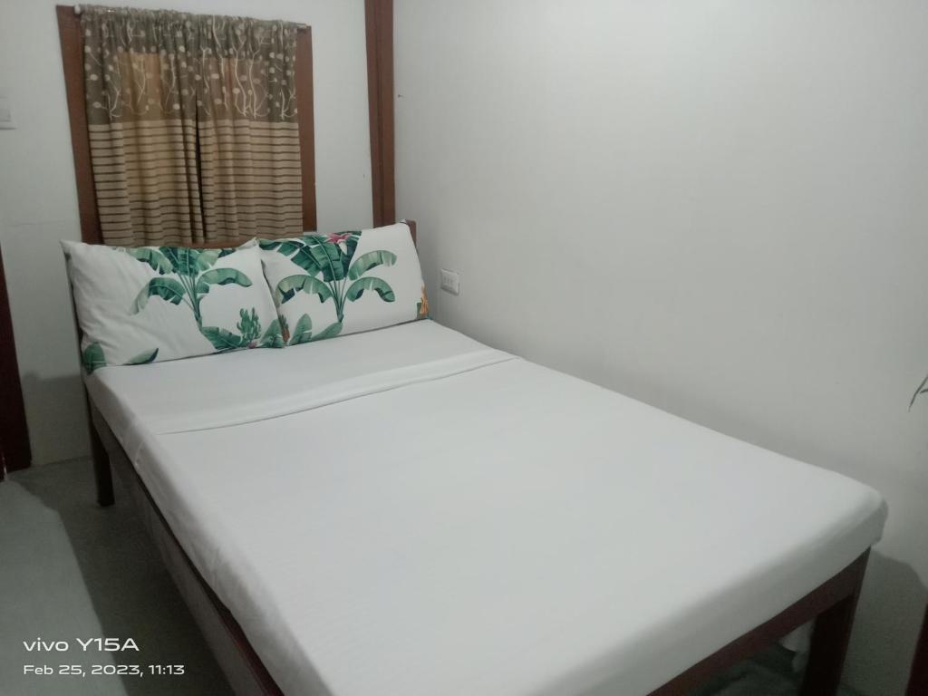 a white bench in a room with two pillows at Vincent Lloyd's Guestroom in San Vicente