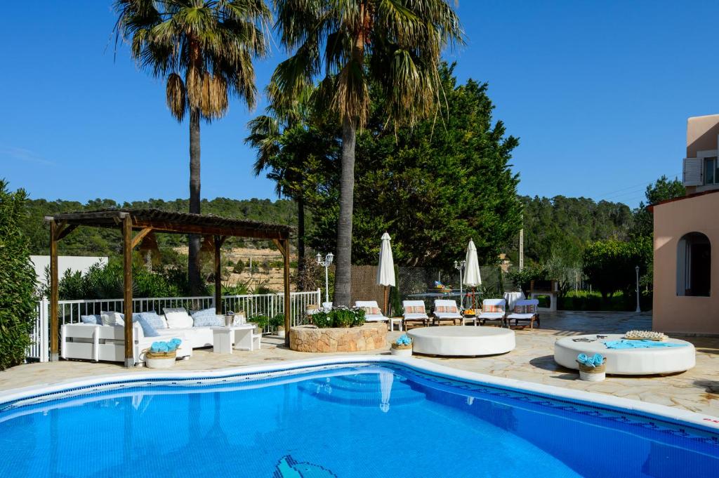 una piscina con sillas y un cenador en Villa Cas Puig - Beach of Portinatx en Portinatx