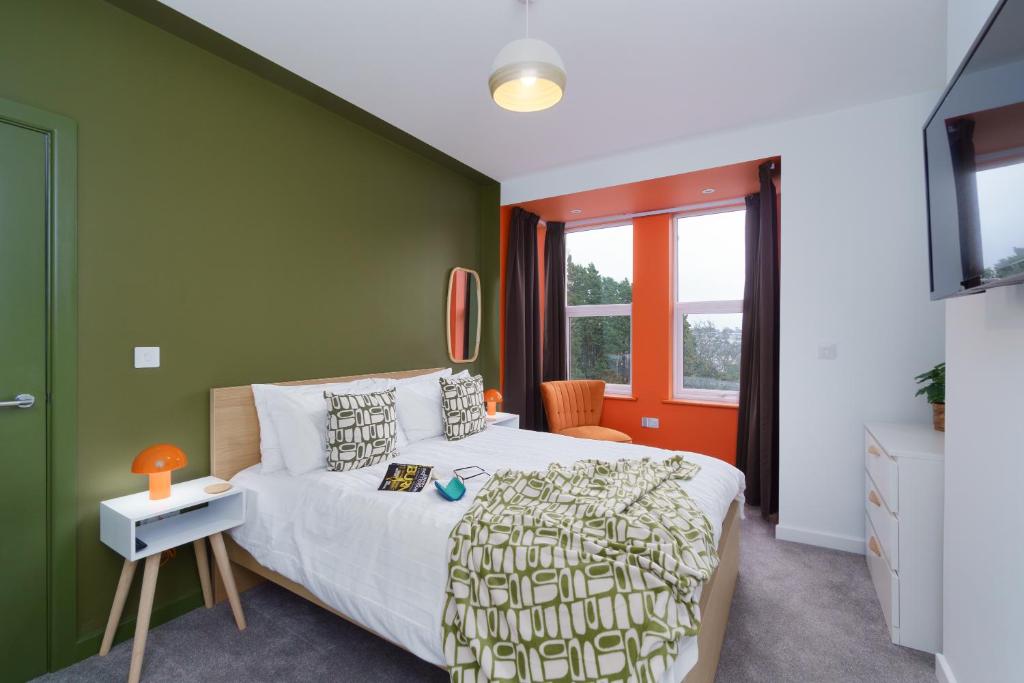 a bedroom with a green accent wall and a bed at Apartment Two - private car park, comfortable and well equipped - by Ocean City Retreats in Plymouth