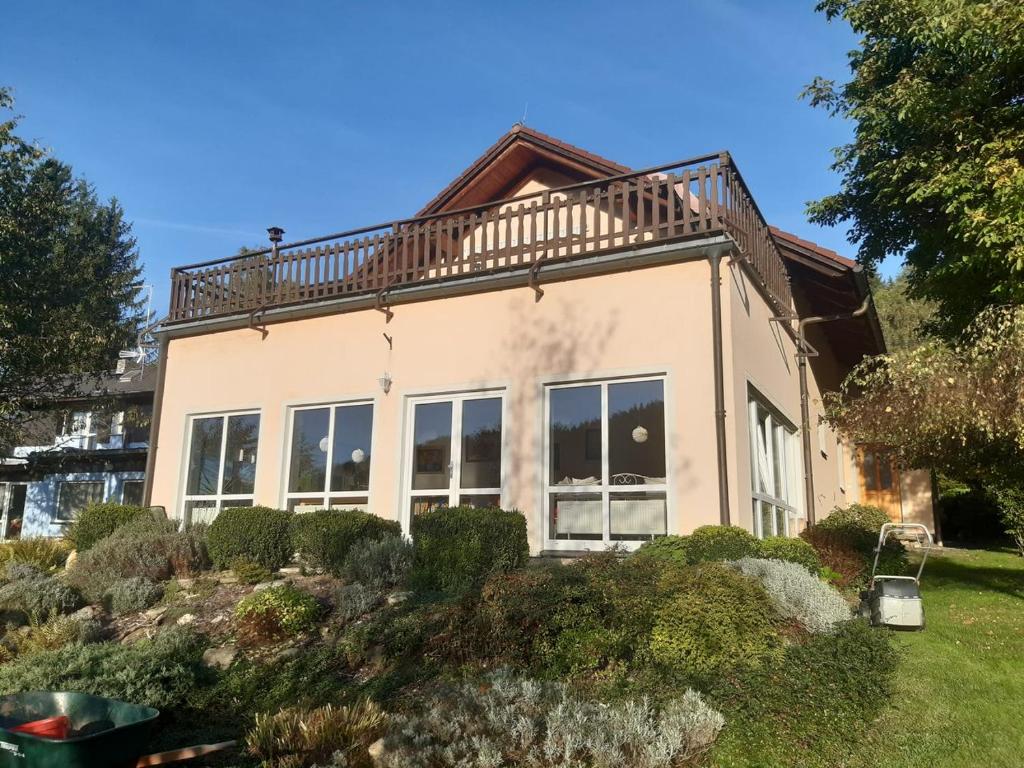 a house with a balcony on top of it at Penzion Montana in Nýrsko