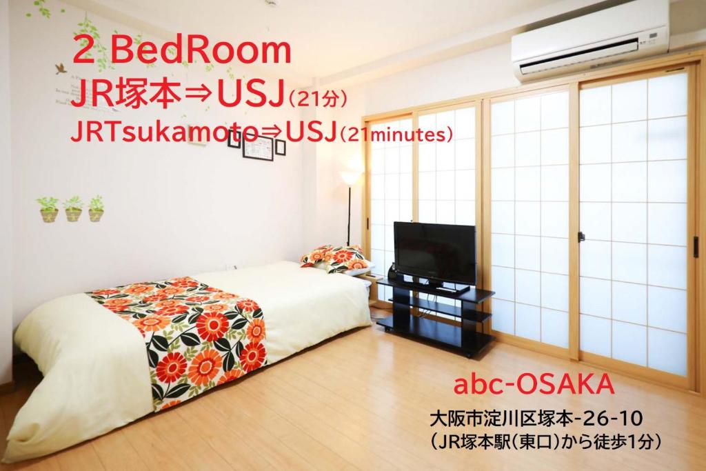 1 dormitorio con 1 cama y TV de pantalla plana en abc OSAKA en Osaka