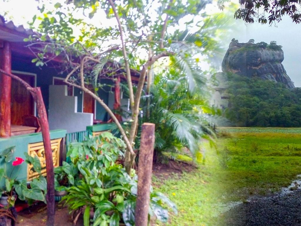 una casa con un árbol delante de ella en Bandula Home Stay en Sigiriya