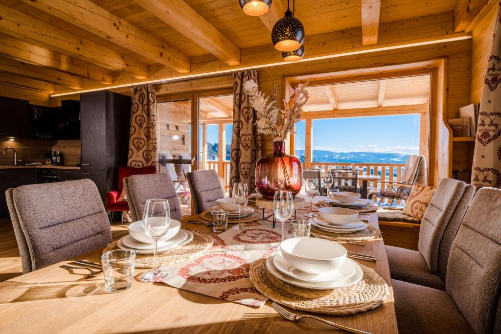 una sala da pranzo con tavolo, sedie e una finestra di Hochleben-Chalets am Erlebnisbauernhof Steinerhof a Liebenfels