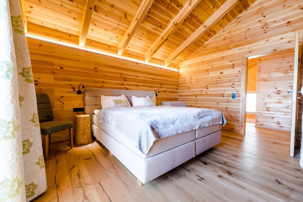 una camera da letto con un letto in una stanza di legno di Hochleben-Chalets am Erlebnisbauernhof Steinerhof a Liebenfels