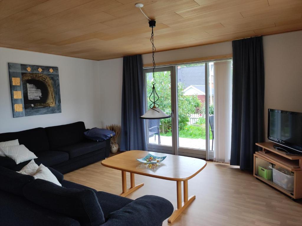 ein Wohnzimmer mit einem Sofa und einem Tisch in der Unterkunft Hjortdal B&B in Fjerritslev