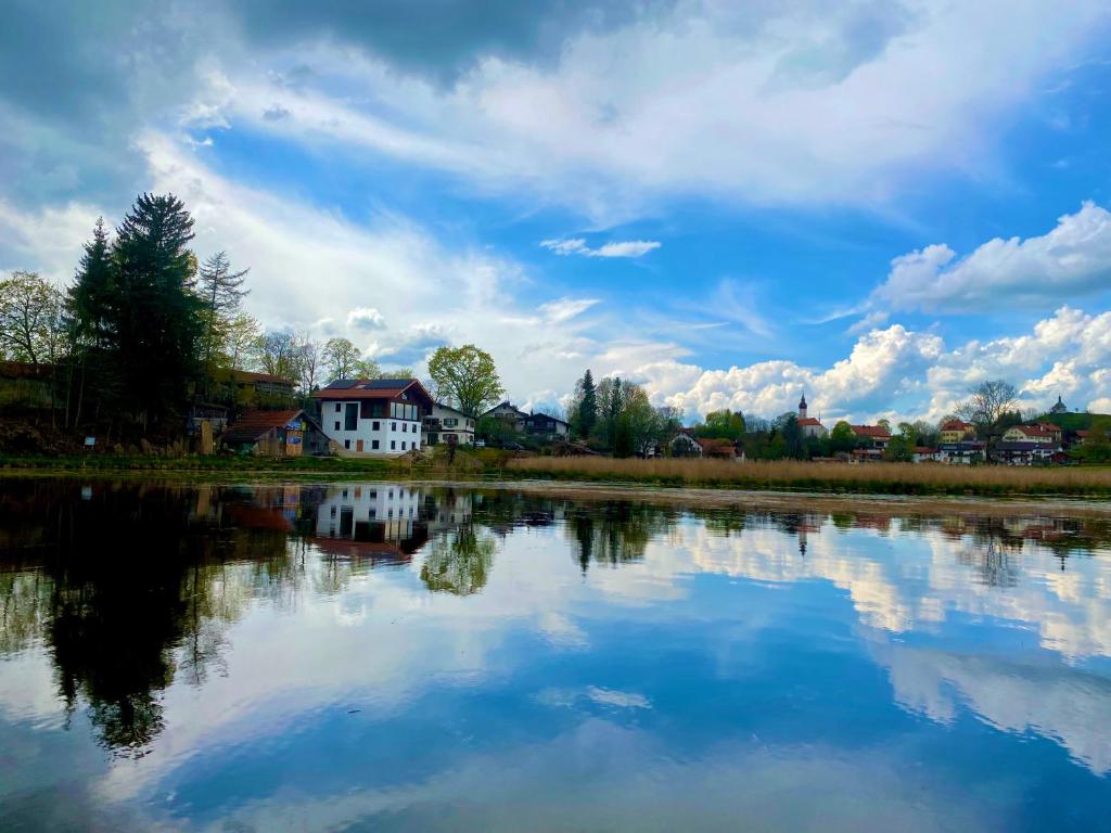 un reflejo de una casa blanca en el agua en Seelodge, en Bad Bayersoien