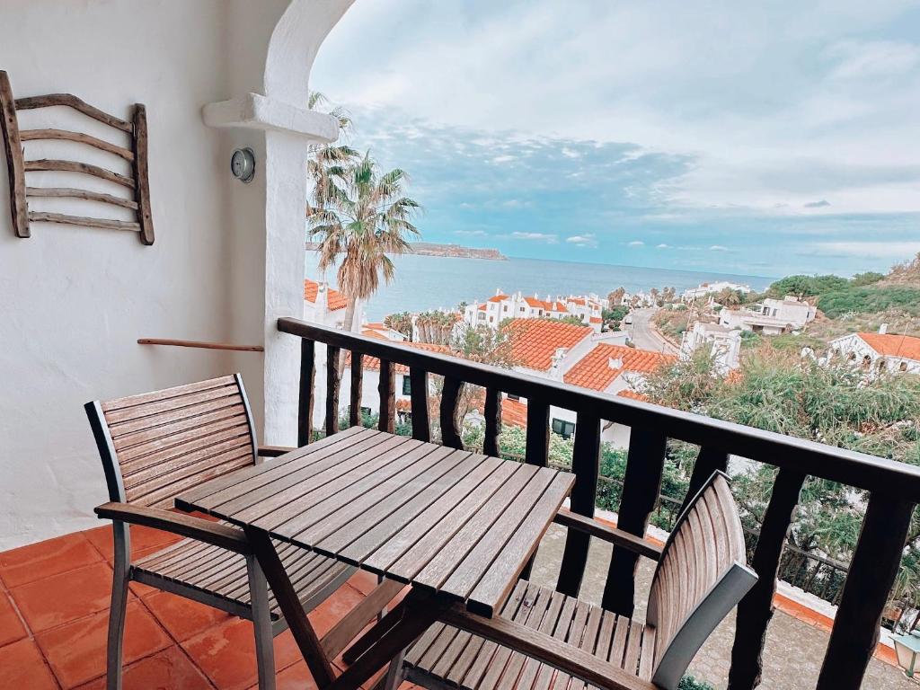 a table and chairs on a balcony with a view of the ocean at Sa caseta de Fornells in Es Mercadal