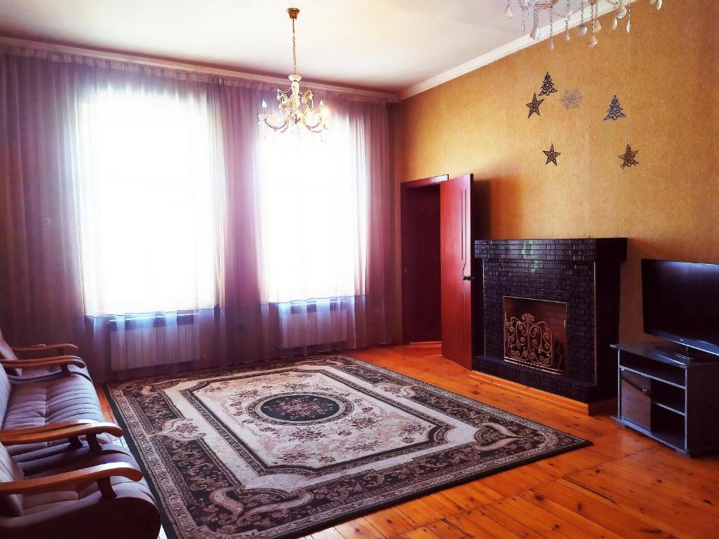 ein Wohnzimmer mit einem Kamin und einem Teppich in der Unterkunft KOSHGARI APARTMENT in Samarkand