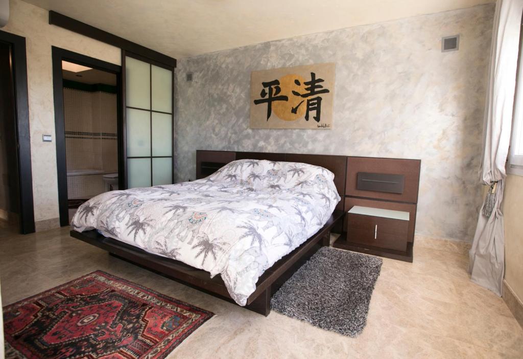 1 dormitorio con cama, mesa y alfombra en Chalet asosado, en Almerimar