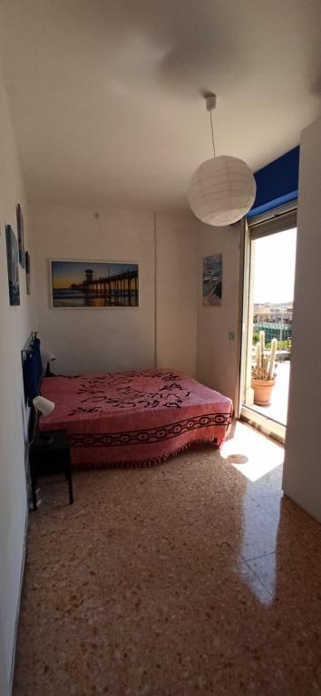 a bedroom with a bed and a large window at Attico Ostia in Lido di Ostia