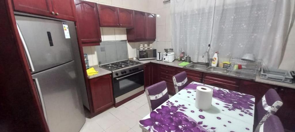 a kitchen with a table with a purple table cloth at Appartamento bello e elegante in west Amman in Amman