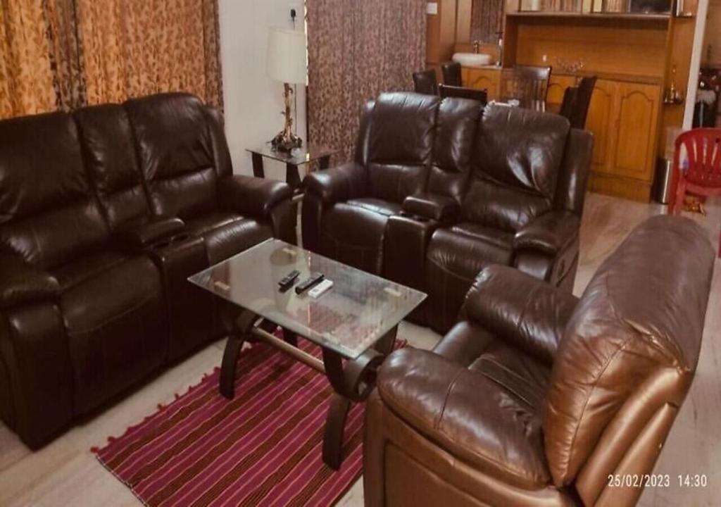 a living room with leather furniture and a coffee table at Best Individual Home stay Near Apollo Jubilee Hills in Hyderabad