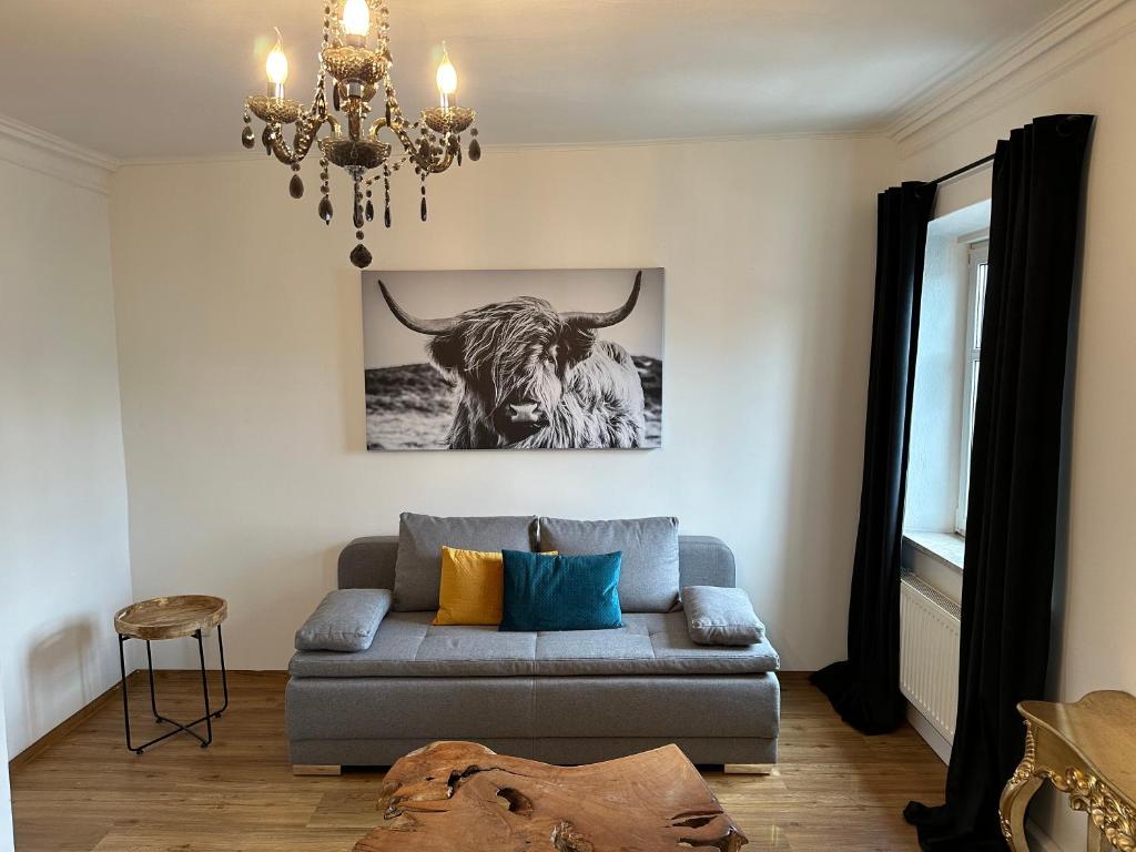 un salon avec un canapé et une photo d'une vache dans l'établissement Mühlbach´s, à Kaufbeuren