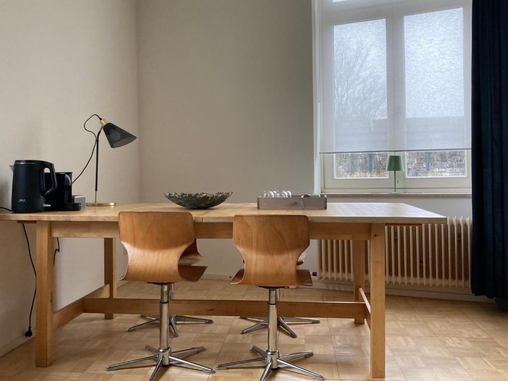 een houten tafel met twee stoelen en een lamp bij B&B De Juliaantjes in Maastricht
