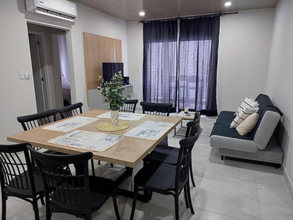 uma sala de jantar com uma mesa e cadeiras e um sofá em Impecable y nuevo, zona aeropuerto! em Assunção