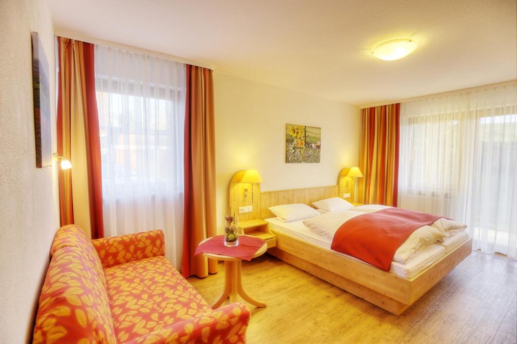 Habitación de hotel con cama y silla en Pension Fohrenberg, en Ewattingen