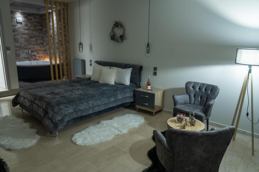 a bedroom with a bed and two chairs at Guesthouse Aelia in Kato Loutraki