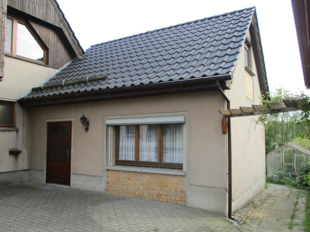 een klein huis met een zwart dak bij Ferienwohnung am See 