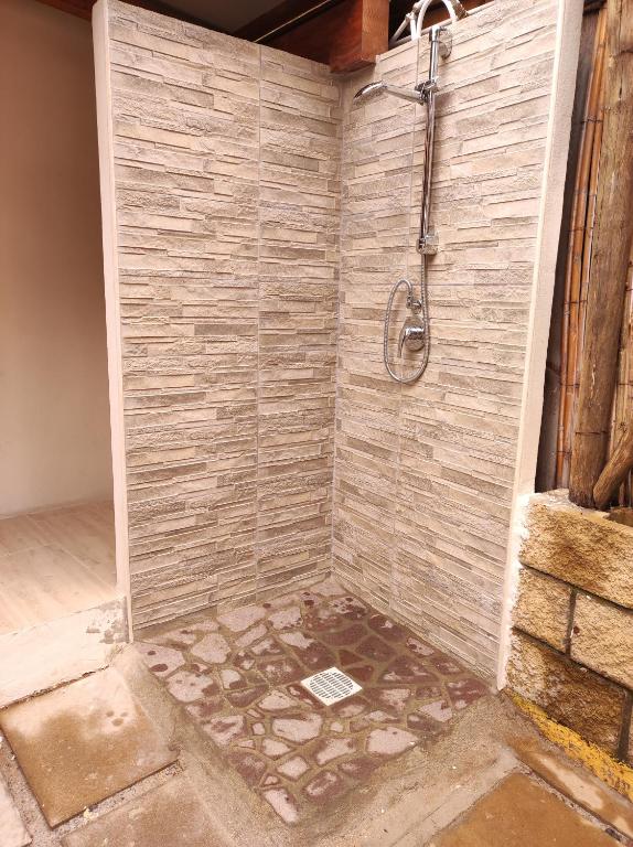 un bagno con doccia e parete in pietra di Casa del Pino a Porto Pino