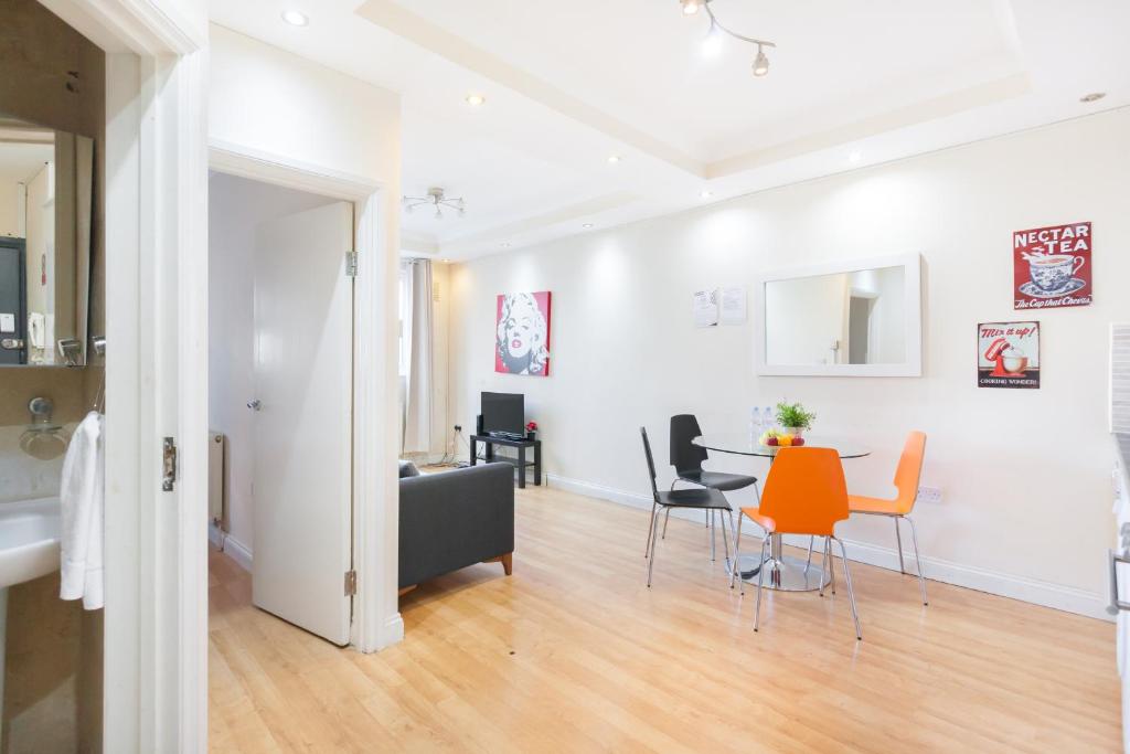 una sala de estar con una mesa y sillas en Kings Cross Prime Stay Apartments, en Londres